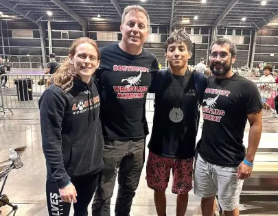 Coach Owen and coaches with wrestler at unstoppable wrestling tournament Gilbert, AZ
